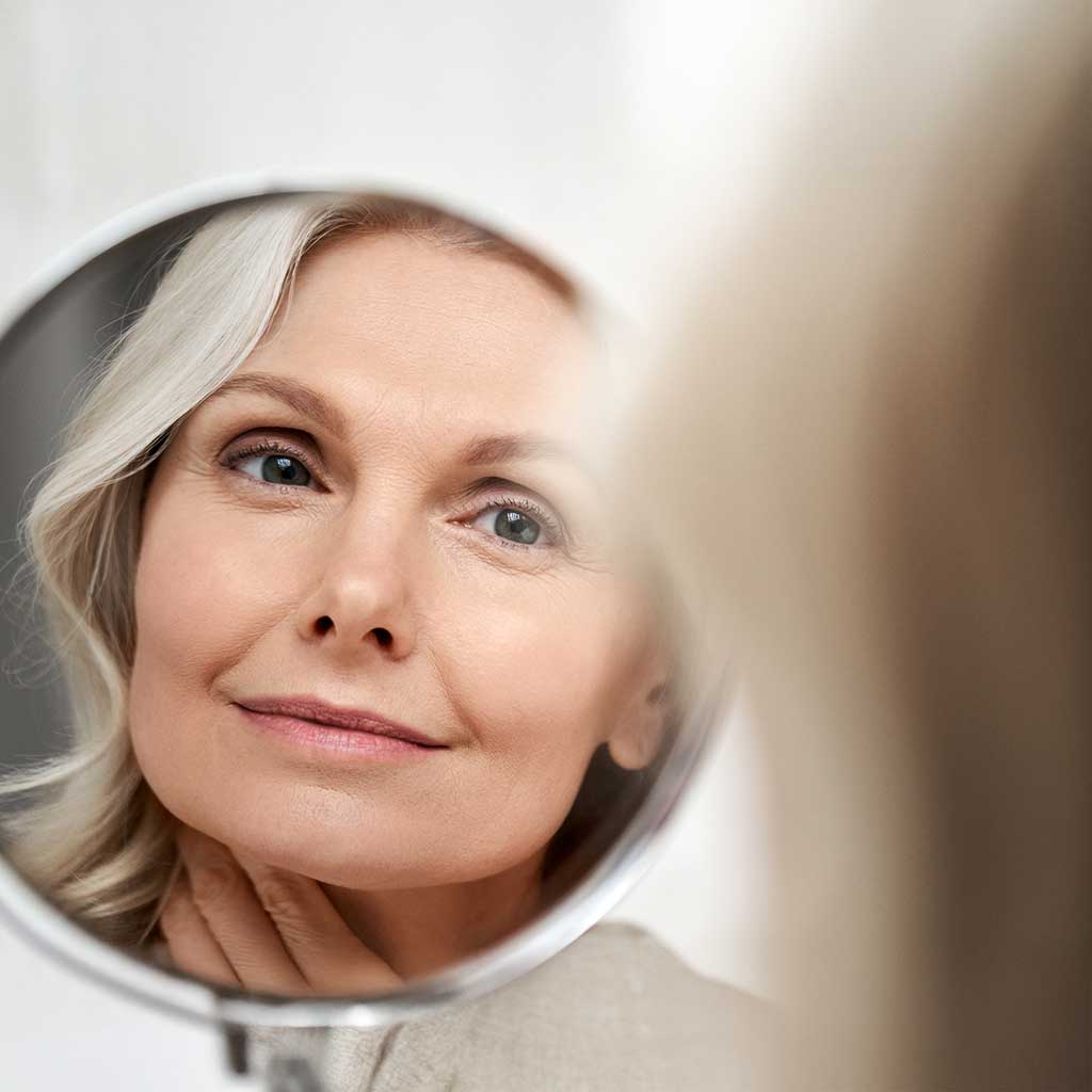 Vita Infusion - Ein Frau schaut in den Spiegel